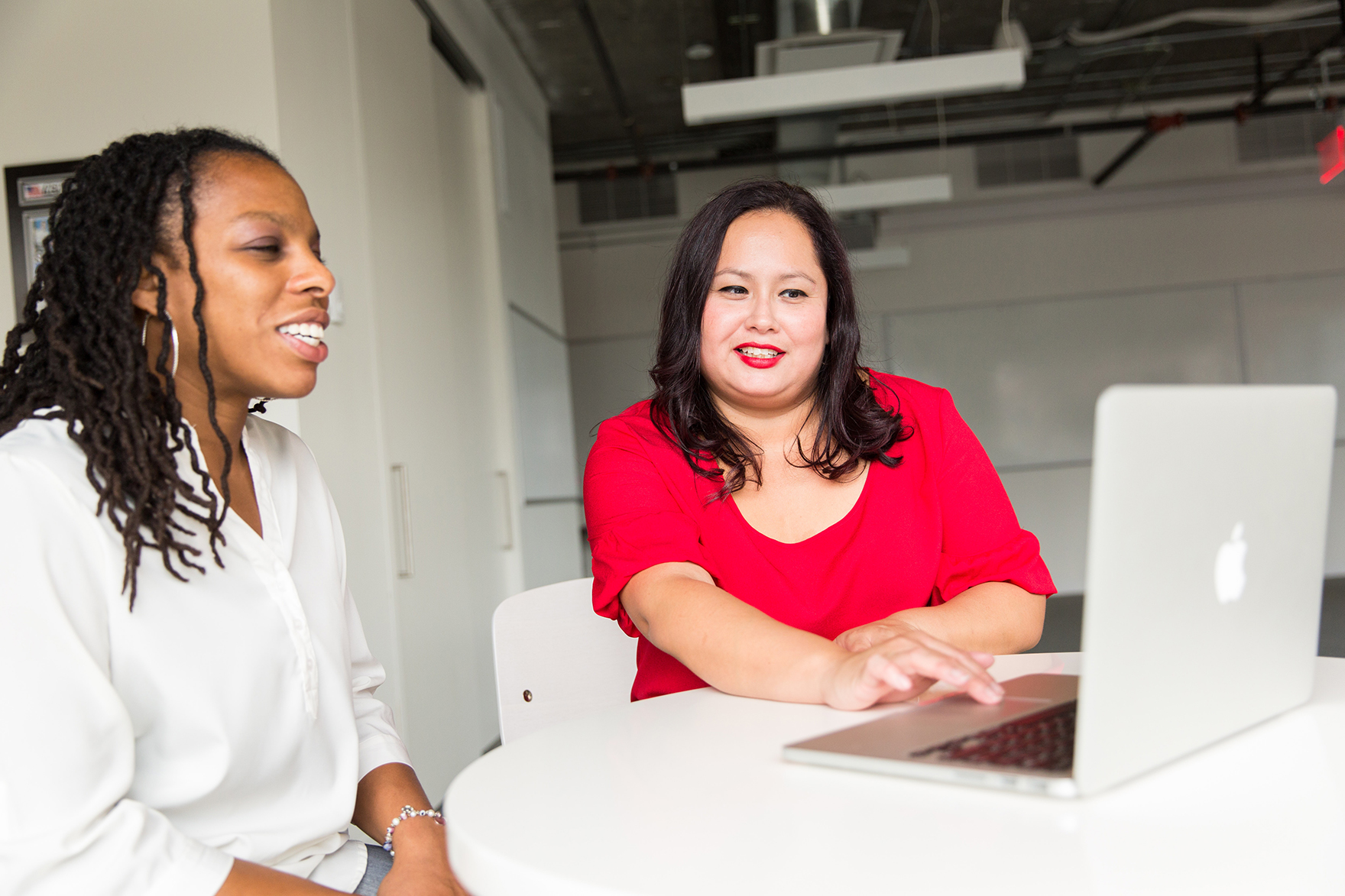 Two people sitting at with a laptop